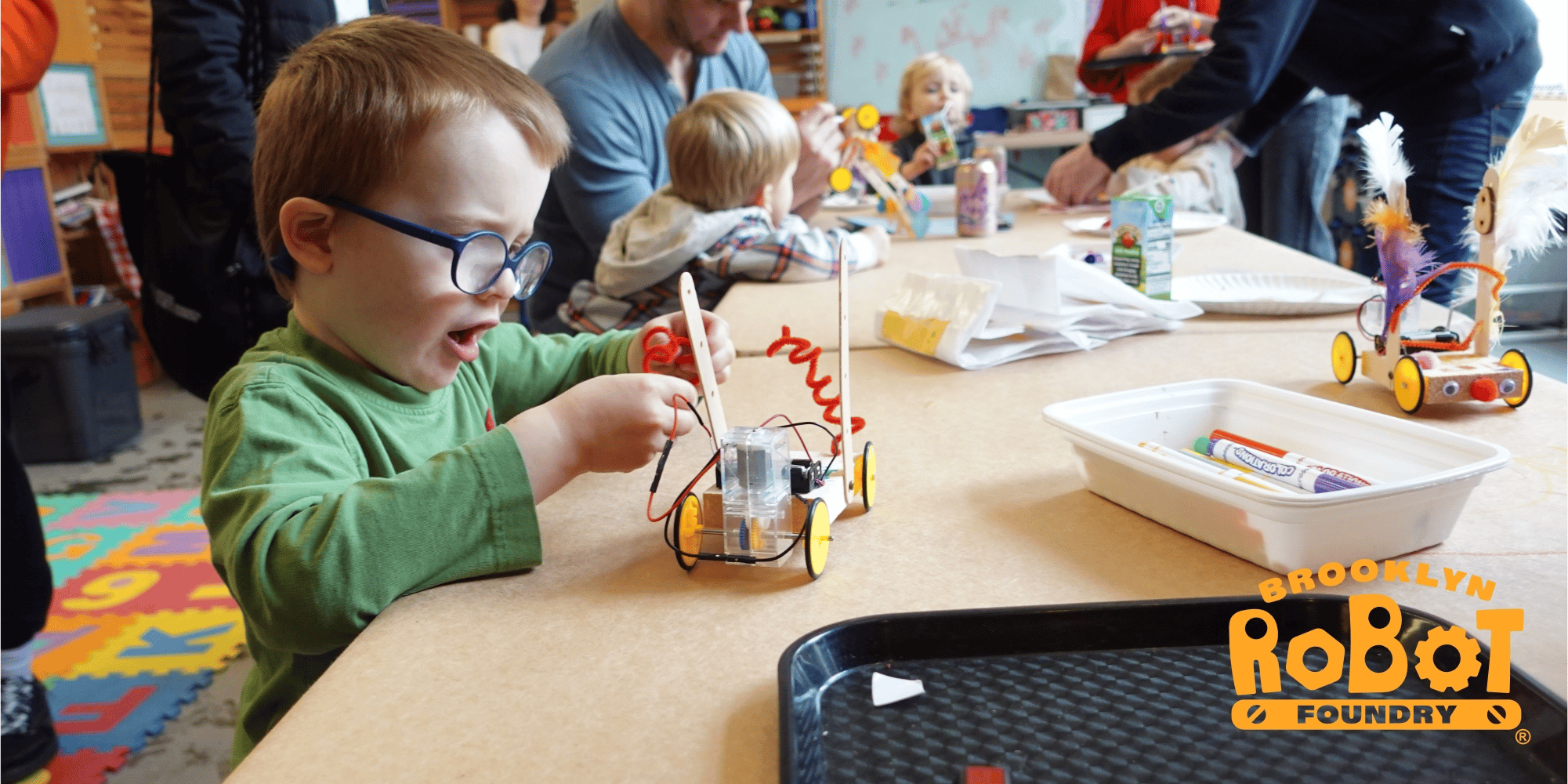 Children proudly demonstrating their robotics project